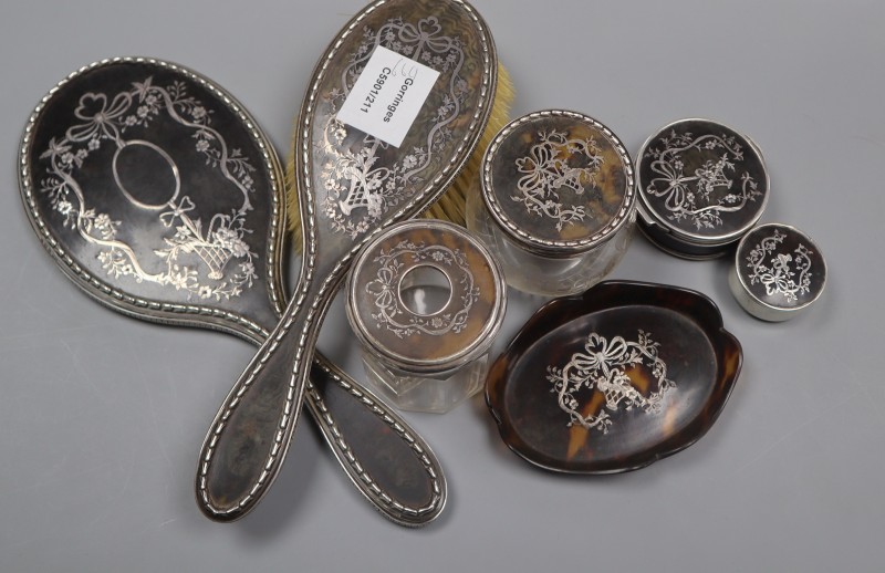 An early 20th century matched seven piece tortoiseshell and silver mounted dressing table set